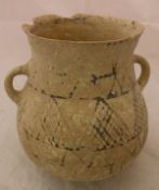 An ancient near Eastern pottery buffware two handled jar with geometric design flanked by two plain