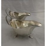 An Edwardian silver cream jug with embossed floral and animal motifs to include dog, swans, etc,