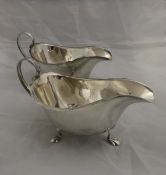 An Edwardian silver cream jug with embossed floral and animal motifs to include dog, swans, etc,