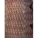 A Bokhara Torba rug, the main panel set with repeating tile design on a dark red ground,