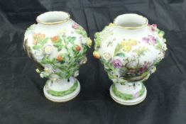 A pair of Carl Thieme Potschappel vases of pear form with floral encrusted decoration enclosing