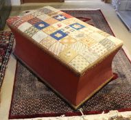 A Victorian upholstered box ottoman with needlework decorated seat over waisted sides on squat bun