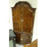 A walnut free-standing corner cupboard in the early 18th Century manner,