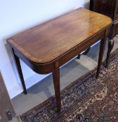 An early 19th Century mahogany and cross-banded fold-over card table of rounded rectangular form,