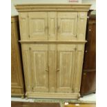 A 19th Century Continental stripped pine cupboard with two small fielded panel doors over two