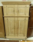 A 19th Century Continental stripped pine cupboard with two small fielded panel doors over two