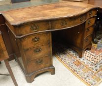 An early 20th Century mahogany pedestal desk of serpentine form in the George III manner,