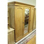 A Victorian waxed pine triple wardrobe compactum