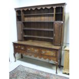 A George III North Country English oak and mahogany cross-banded dresser with four tier boarded