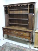 A George III North Country English oak and mahogany cross-banded dresser with four tier boarded