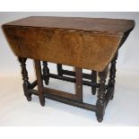 A 19th Century oak oval gate-leg drop leaf dining table with single end drawer on baluster turned