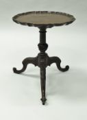 A mahogany wine table in the George III taste, the circular top with pie-crust rim,