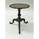 A mahogany wine table in the George III taste, the circular top with pie-crust rim,