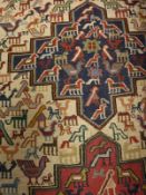 A Caucasian style rug, the central panel set with three medallions with stylised bird,