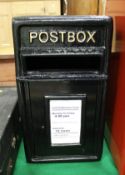 A black painted cast metal postbox inscribed "Postbox"