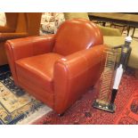 A modern red leather upholstered armchair in the Art Deco style together with a Blackamoor CD rack