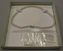 A Mitsukoshi simulated single strand pearl necklace with matching earrings, 42.