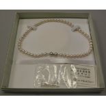 A Mitsukoshi simulated single strand pearl necklace with matching earrings, 42.