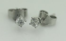 A pair of 9ct white gold and solitaire diamond stud earrings