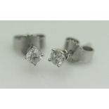 A pair of 9ct white gold and solitaire diamond stud earrings