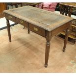 An India Jane teak three drawer writing table with faux crocodile skin cover,