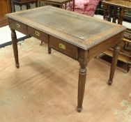 An India Jane teak three drawer writing table with faux crocodile skin cover,