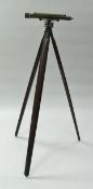 An anodised brass theodolite on folding wooden tripod stand