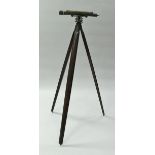 An anodised brass theodolite on folding wooden tripod stand