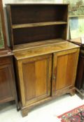 A Victorian stained pine side cabinet with two tier superstructure over two doors on bracket feet,