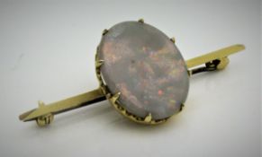 An opal set bar brooch, the opal of oval form with gold coloured mount, un-marked,