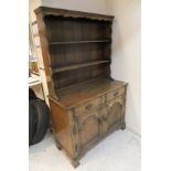 A modern oak Welsh type dresser with two tier boarded plate rack over two drawers and two cupboard