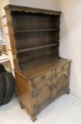 A modern oak Welsh type dresser with two tier boarded plate rack over two drawers and two cupboard