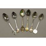 A collection of various souvenir spoons,