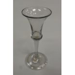 An 18th Century wine glass with thistle bowl and plain stem on a circular folded foot