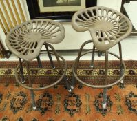 A pair of modern painted cast iron adjustable tractor seat stools