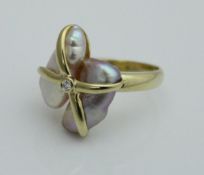 An 18ct gold ladies dress ring set with two blister pearls in an abstract setting with central