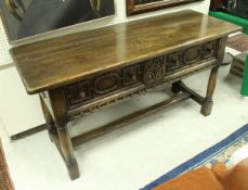 A modern oak two drawer serving table in the 17th Century manner with carved decoration on turned