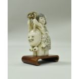 A 19th Century Japanese carved okimono as a young girl riding on the back of an anthropomorphised