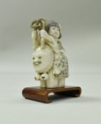 A 19th Century Japanese carved okimono as a young girl riding on the back of an anthropomorphised