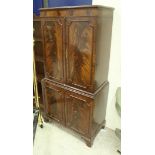 A modern reproduction mahogany cabinet with two pairs of cupboard doors on bracket feet,
