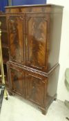 A modern reproduction mahogany cabinet with two pairs of cupboard doors on bracket feet,