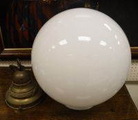 An Art Deco style ceiling light with plain milk glass globe on a brass suspension fitting