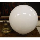An Art Deco style ceiling light with plain milk glass globe on a brass suspension fitting