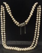 A vintage double strand faux pearl necklace with decorative clasp and safety chain,