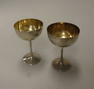 A matched pair of Edwardian silver goblets of plain circular form,