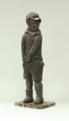 A 19th Century carved oak figure of a young boy in cap, his right hand in his shorts pocket,