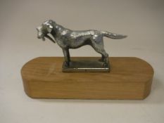 A modern chrome plated car mascot as a Labrador with pheasant quarry in mouth,
