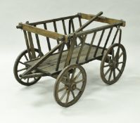 A wooden dog cart twin axle with spoked iron rimmed wheels,
