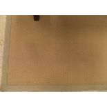 A modern seagrass style woven rug of neutral colour with sage binding measuring 610 cm by 350 cm