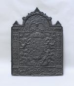 A 19th Century cast iron fireback in the 17th Century manner decorated with Royal Coat of Arms held